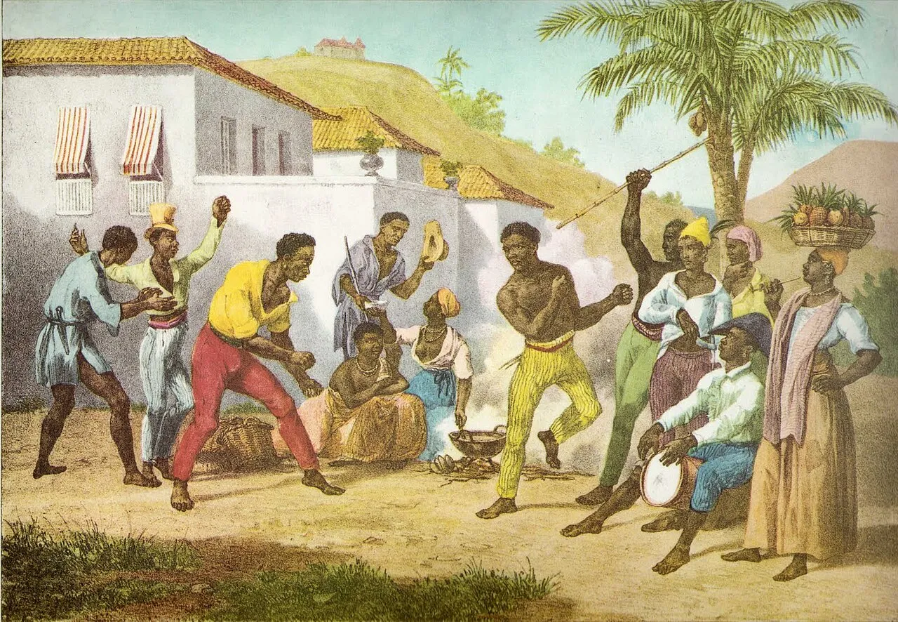 Capoeira jogo inside a roda: two capoeiristas exchange kicks and ginga while the bateria plays berimbau and percussion. Capoeira combines striking, acrobatic evasion, and sweeps in a continuous movement game.