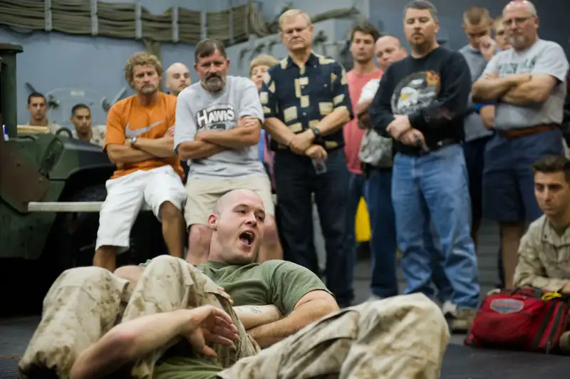 A U.S. Marine demonstrating a heel hook technique aboard USS Pearl Harbor — showing the leg control and heel grip that define the submission accessed via the Imanari roll. Public domain, U.S. Marine Corps photo