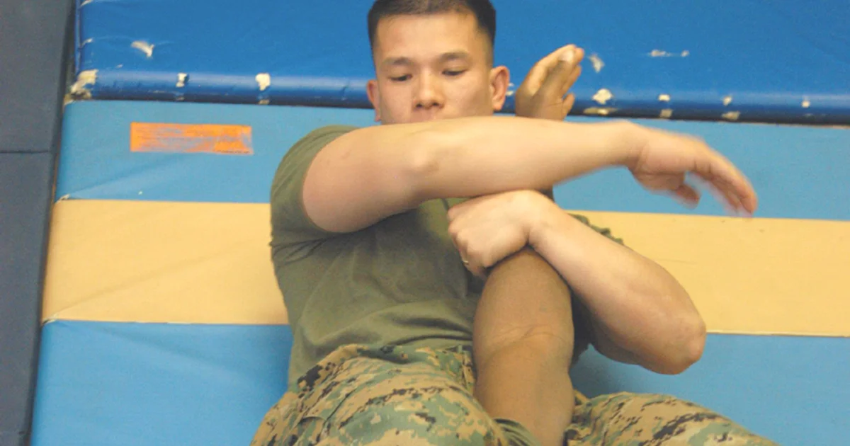 Juji-gatame armbar aplicado da guarda — o atacante está deitado perpendicularmente, as pernas prendendo o ombro do adversário, o quadril fazendo ponte contra o cotovelo para hiperestender a articulação.